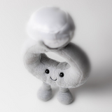 Gray plush toy with a smiling face on a white background