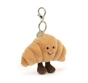 Plush croissant charm with a key ring on a white background