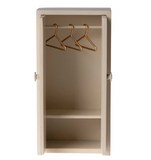 Beige wardrobe with gold hooks on a white background