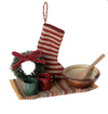 Miniature Christmas scene with a striped stocking, wreath, mugs, and bowl on a white background.