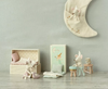 Children's room with toys and furniture against a light gray wall.