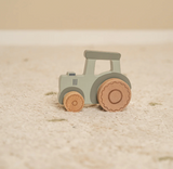 Wooden toy tractor on a beige surface