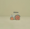 Toy tractor with gray body and red wheels on a beige background