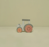Toy tractor with gray body and red wheels on a beige background