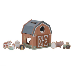 Wooden toy barn with farm animal figures on a white background