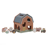 Wooden toy barn with animal figures on a white background
