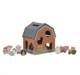 Wooden toy barn with animal figures on a white background