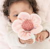 Child holding a pink flower-shaped toy