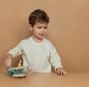 Child playing with a wooden toy on a beige background