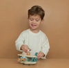 Child playing with a wooden toy on a brown background