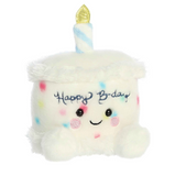 Plush toy shaped like a birthday cake with a candle and 'Happy Birthday' text on a white background