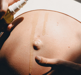 Person applying a liquid substance to a person's back with a dropper bottle.