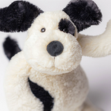 Close-up of a plush toy dog with black and white fur on a light background