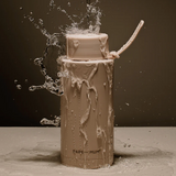 Bare-Mum tumbler with water splashing out against a dark background