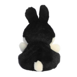 Black plush toy with white paws on a white background