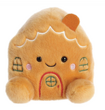 Plush toy shaped like a gingerbread house with a smiling face on a white background