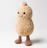 Plush toy shaped like a peanut with a smiling face on a white background