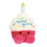Plush toy shaped like a birthday cake with a candle and 'Happy Birthday' text on a white background
