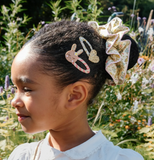 Child with decorative hair clips in a garden setting