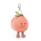 Plush peach-shaped keychain with legs and a smiling face on a white background