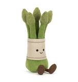 Plush toy of green asparagus with a smiling face on a white background