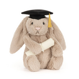Plush toy rabbit wearing a graduation cap and gown on a white background