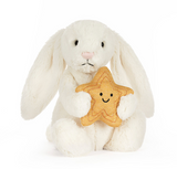 White plush bunny holding a star-shaped cookie with a smiley face on a white background