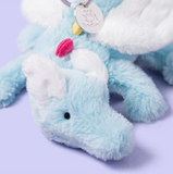 Plush toy elephant with a blue trunk on a light purple background
