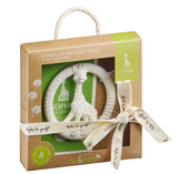 Sophie de la girafe baby teething ring in its original packaging. The white textured rubber teething ring features a giraffe design and is shown inside a brown kraft paper box with a green label, tied with a cream-colored printed ribbon.