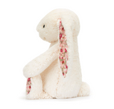 White plush bunny with floral ear on a white background