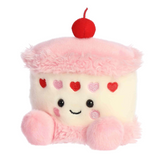 Plush toy shaped like a cupcake with pink frosting and a cherry on top, on a white background.