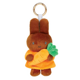 Plush keychain of a brown bunny holding a carrot on a white background