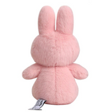 Pink plush toy with a visible brand tag on a white background