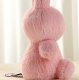 Pink plush bunny toy on a light background