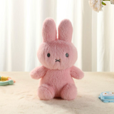 Pink plush bunny toy on a light surface with a blurred background