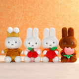 Four plush toys resembling bunnies with different accessories on a beige background