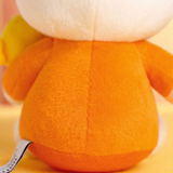 Close-up of a plush toy with an orange body and white head on a yellow background