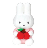 White plush toy with red shoes and a green leaf on a white background