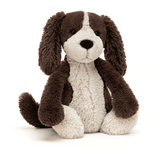 Stuffed dog toy with brown and white fur on a white background