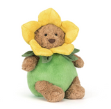 Plush toy bear with a yellow flower hat and green dress on a white background