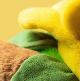 Close-up of a green towel with a yellow and brown object underneath on a yellow background