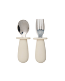Set of children's cutlery with white handles and silver utensils on a white background
