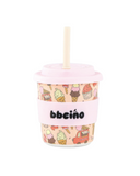 Pink cup with ice cream pattern and straw on a white background