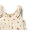 Beige sleeveless top with red floral patterns on a white background