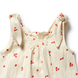 Beige baby dress with red floral patterns on a white background