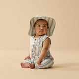 Baby wearing a striped romper and hat on a beige background