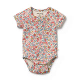 Floral patterned baby bodysuit on a white background