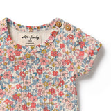 Floral baby romper with button details on a white background