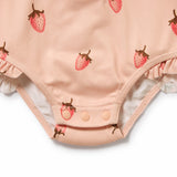 Pink baby onesie with strawberry pattern on a white background