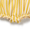 Close-up of yellow and white striped fabric with ruffled edge on a white background